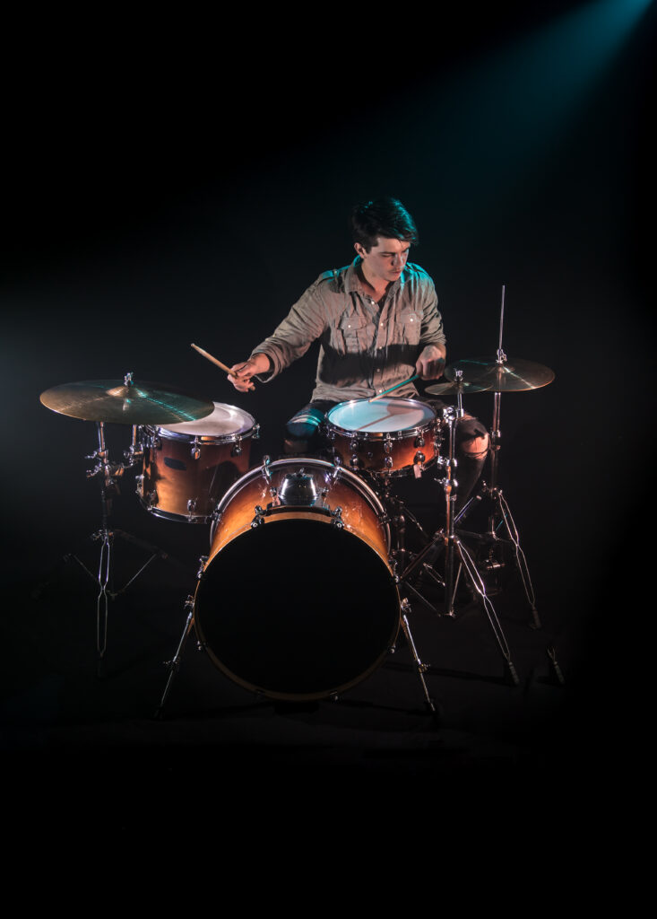 musician playing drums, black background and beautiful soft light